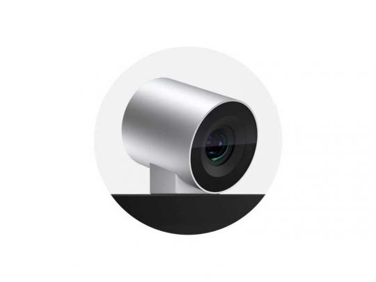 Microsoft Surface Hub 2S Webcam—A sleek, silver and black cylindrical webcam with a front-facing lens is securely mounted on the edge of a black flat surface, shown against a plain white background.