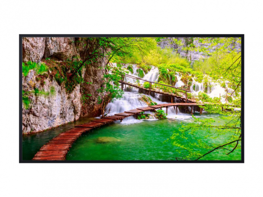 Wooden footbridge spanning emerald-green water with small cascading waterfalls, surrounded by lush greenery and rocky cliffs in a vibrant natural landscape.