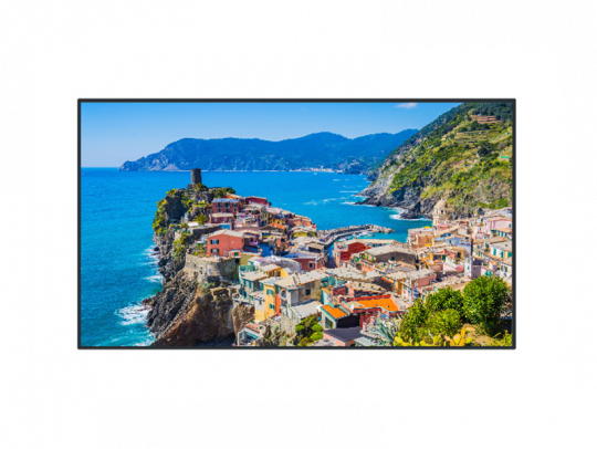 Colorful seaside village with pastel houses perched on rocky cliffs above a blue sea, green hills in the background, and a bright clear sky—picturesque coastal scene ideal for Mediterranean travel inspiration.