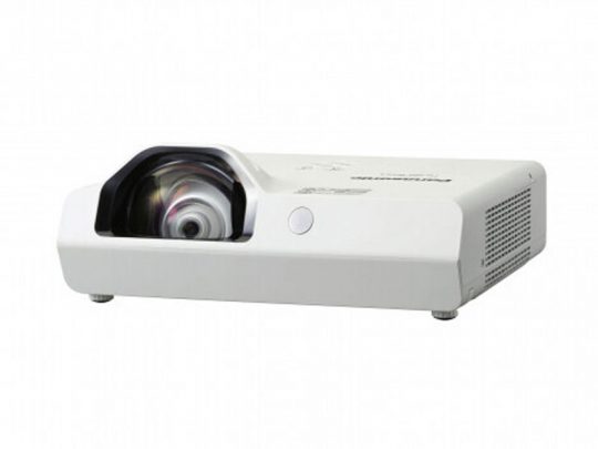 White short-throw projector with a large lens on the left and ventilation openings on the right, displayed on a flat surface against a white background. Ideal for home theater or office presentations.