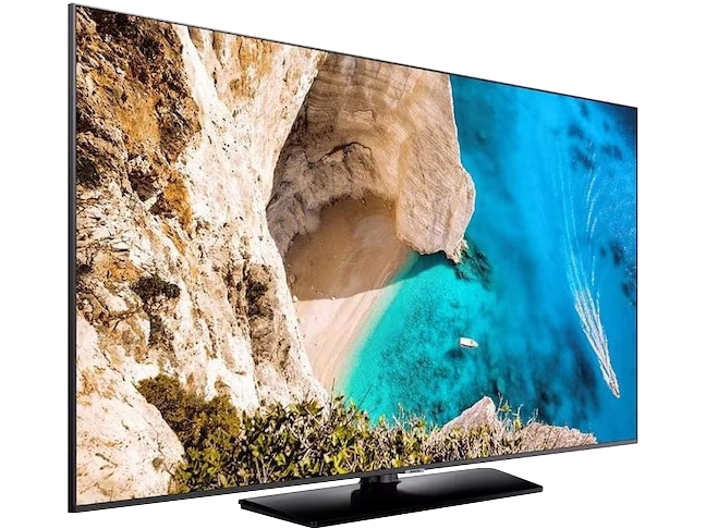 Flat-screen hotel TV displaying vibrant aerial view of a beach with turquoise water, sandy shore, white cliffs, and boats—perfect for enhancing guest experience in hotels.