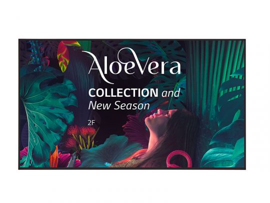 Promotional poster for the Aloe Vera Collection featuring lush, colorful tropical leaves and flowers with a woman looking upward; text reads Aloe Vera Collection and New Season 2F.