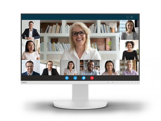 Computer monitor displaying a video conference on screen, with nine diverse participants each in their own video window, all smiling and interacting. Typical video call controls are visible at the bottom of the display, showing an online meeting setup using a modern conferencing platform.