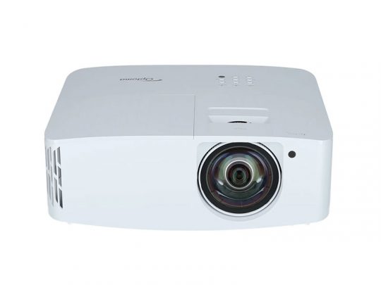 Optoma projector front view – white projector with prominent lens on the right, control buttons visible on the top, ideal for presentations and home cinema.