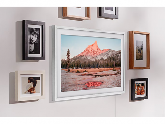 Samsung The Frame 32 Zoll FullHD QLED-TV an einer Wand montiert, im schlanken, modernen Rahmen-Design. Das Display zeigt ein Kunstwerk und wirkt wie ein Bilderrahmen - ideal zum Anzeigen von Kunst, Fotos oder TV-Inhalten. Perfekt als stilvolle Galerie-Wand für Ihr Zuhause; Sie können das Gerät mieten oder kaufen.