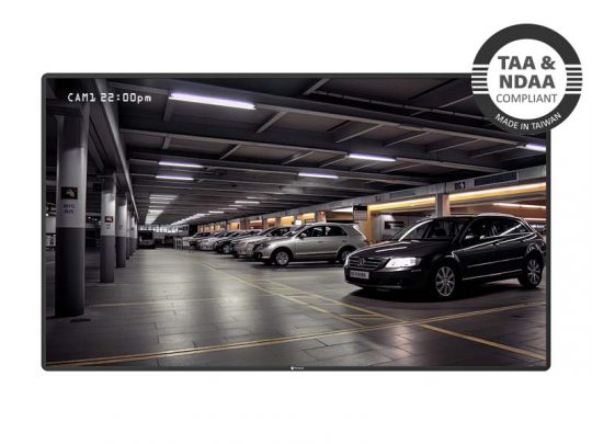 Bildschirm zeigt Sicherheitskamera-Aufnahmen eines gut beleuchteten, überdachten Parkhauses mit geparkten Autos; im oberen rechten Eck ein Badge mit der Aufschrift "TAA & NDAA konform, hergestellt in Taiwan". Das Bild präsentiert die Videoüberwachungslösung für Parkhäuser.